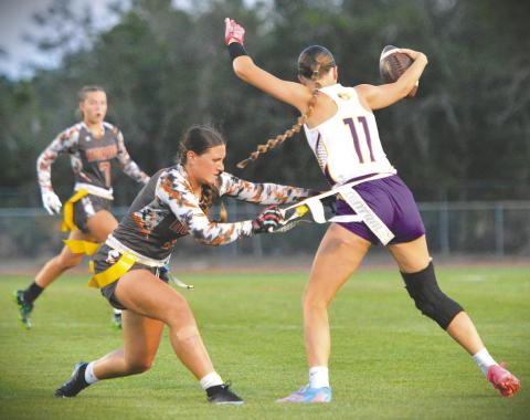 Harmony’s Khloe Cook-Osani pulls the flag of Fort Pierce Central’s Braelyn Hartnett in Thursday’s regional final, a 15-7 Harmony win. (Photo/Katie Williams)