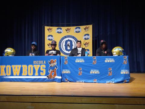 Surrounded by family, friends and Coach Eric Pinellas, Jakeem Jackson (signed with Florida), Derrick Leblanc (Oklahoma), John Walker (UCF) and Bo Mascoe (Rutgers) all inked scholarship papers to play Division-I football during Wednesday’s National Signing Day. PHOTO/DAN PEARSON