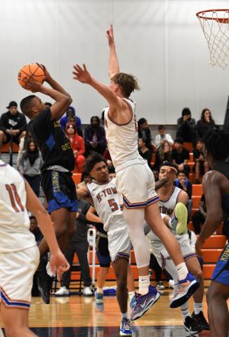 Osceola's Alex Springs goes up for a shot and Caden Scarborough defends in Friday's OBC boys basketball championship game. PHOTO/KATIE WILLIAMS