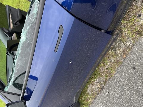 Bullet holes in the driver's door and side window of a blue Tesla which was involved in a road rage incident on northbound Florida's Turnpike just leaving Osceola County. PHOTOS/FHP
