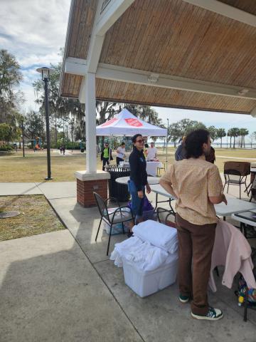Volunteers from the Hope Partnership and Salvation Army provide food, blankets, toiletries and other necessities at the Kissimmee Lakefront Wednesday afternoon, before heading out to conduct the Point-In-Time Count of local homeless. PHOTO/KEN JACKSON