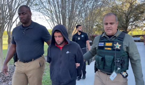 Osceola County Sheriff Marcos Lopez leads Julio Ramos-Aleman to a cruiser Friday to be booked into the Osceola County Jail, after police say he stabbed his wife multiple times early that morning.. PHOTO/OSCEOLA COUNTY SHERIFF'S OFFICE