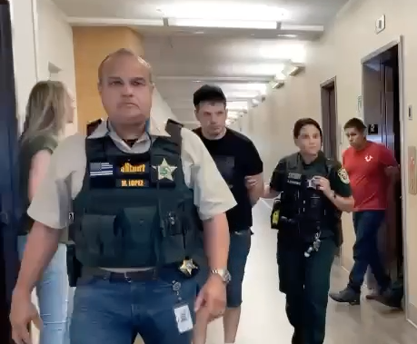 Police lead away Alejandro Campuzano-Moreno (black shirt) and Jose Pena-Silva (red shirt) following their arrest in a recent “jugging” scheme. PHOTO/OSCEOLA COUNTY SHERIFF’S OFFICE