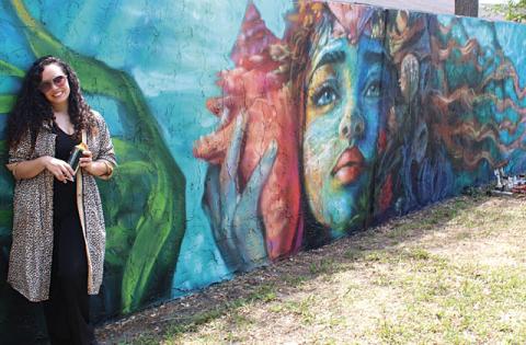 Artists Jennifer Veal (pictured), Gabriella Shepherd, Eric “The Wise Knight” Wise, and Mike “2Esae” Baca collaborated on 180 feet of wall mural adjacent to The Transition House in Kissimmee in the latest installment of Osceola Arts’ ARTisNOW public works project. (Photos/Ken Jackson)