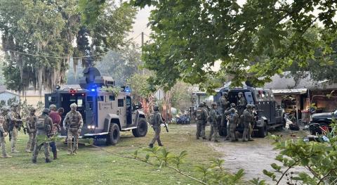 Members of the Kissimmee and St. Cloud Police Department tactical teams descend on a home on New Nolte Road Thursday morning. Eleven arrests were made and more than 60 pieces of evidence were seized. (Photo/St. Cloud Police Department)