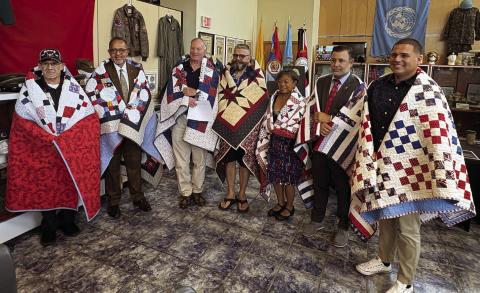 Quilt of Valor recipients, right to left: Carlos Guzman; Mike Adams; Myrna Callison; David Witke; Robert Callison; Fred Robinson, and Harold Borrero. (Photo/Terry Lloyd)
