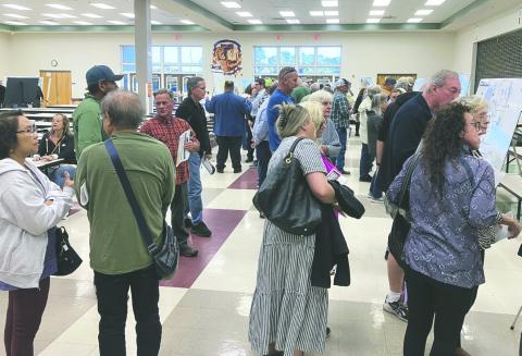 A few dozen residents of the hundreds in attendance at a community meeting at Harmony High last week examine displays of the routes being evaluated for the Northeast Connector toll road. PHOTO/TERRY LLOYD