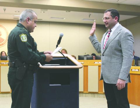 He solemnly swears: Osceola Sheriff Marcos Lopez swore in School Superintendent Mark Shanoff as an honorary Special Deputy last week. PHOTO/KEN JACKSON