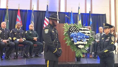 Police officers from St. Cloud and Kissimmee stand watch over a memorial wreath after blue roses were added by colleagues and families to honor Osceola County’s fallen law enforcement officers at Tuesday’s annual memorial service. (Photos/Ken Jackson). 