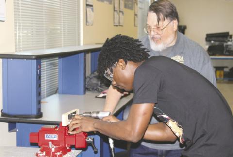 Instructor Steve Arden monitors a student in the Osceola High Aviation II class drilling into aircraft aluminum. PHOTO/TERRY LLOYD