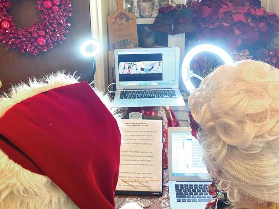 Santa and Mrs. Claus take a photo with two young girls by enabling the gallery view on the Zoom call. NEWS-GAZETTE PHOTO/BRIAN MCBRIDE