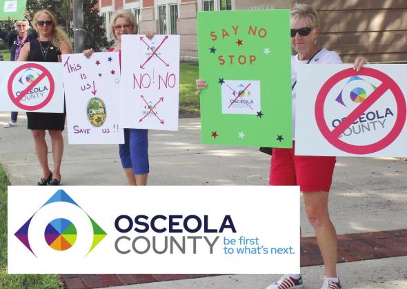 Protestors of the new Osceola County logo hold signs along Emmett Street Monday. PHOTO/KEN JACKSON