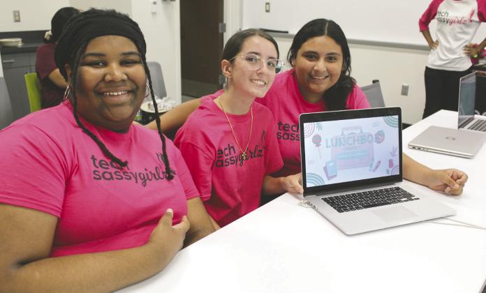 Osceola High and St. Cloud sophomores Lyric Williams, Biana Maandez and Liaian Brandan (from left) show off their “Lunchbox” AI chat bot they created during the Tech Sassy Girlz “Pearls in Tech Accelerator” summer program July 30 at Valencia College. (Photo/Ken Jackson)