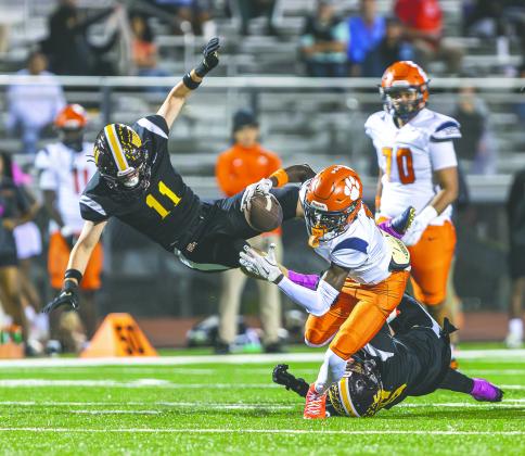 St. Cloud linebacker Chase Gilbert (11) takes to the air and Bryce Williams (5) goes to the ground to bring down Tohopekaliga’s Tre Punter in Friday’s 44-21 Bulldogs win that clinched the District 7A-10 title. (Photo/Taylor McFee)