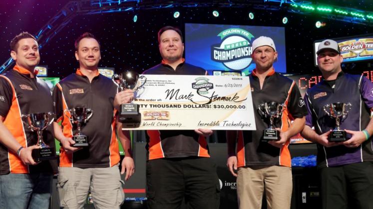 :  Mark Stenmark (center) holds his $30,000 check for winning the 2019 Golden Tee World Championship.  (Photo Courtesy of Incredible Technologies)
