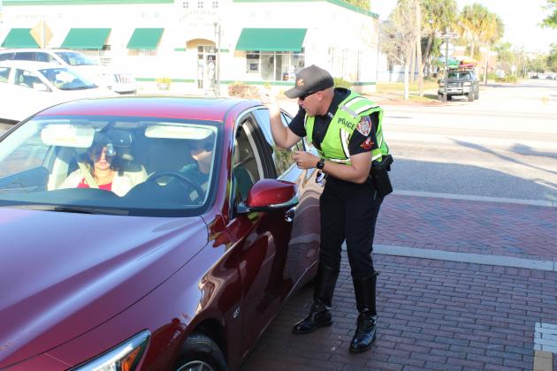 A Kissimmee Police Officer pulls over a driver to inform him that he did not stop for a plain-clothed officer in a crosswalk. NEWS-GAZETTE PHOTO/BRIAN MCBRIDE