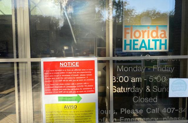 A sign on the front door of the Florida Department of Health-Osceola instructs residents to push a call button and wait outside if they think they have the coronavirus.