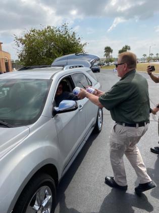 Sheriff Russ Gibson hands out rolls of toilet paper.