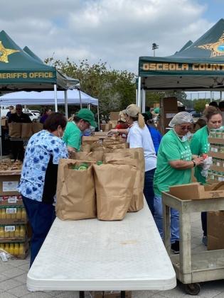 Volunteers bag food items.