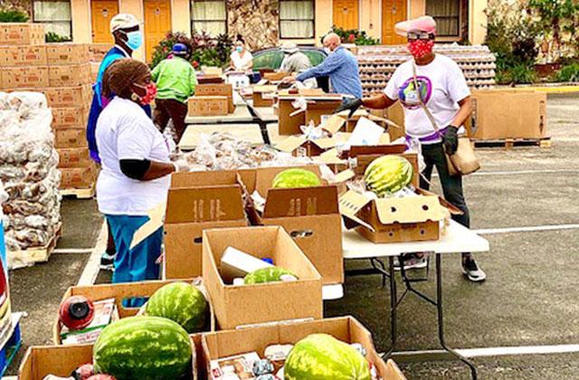 Volunteers with Clarita's House Outreach Ministry prepares the food to be distributed at its drive-through pantry off West U.S. Highway 192 on Thursday. NEWS-GAZETTE PHOTO/BRIAN MCBRIDE