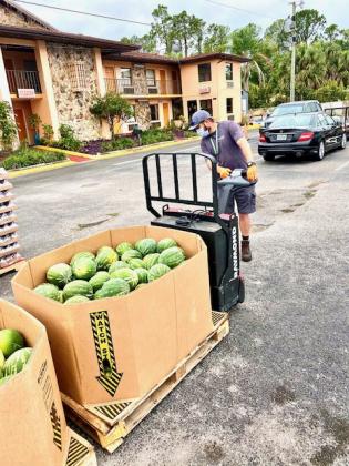 A Second Harvest Food Bank truck driver unloads a box of watermelons. NEWS-GAZETTE PHOTO/BRIAN MCBRIDE