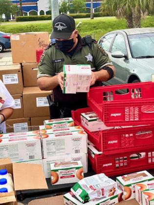 The Osceola County Sheriff's Office helped unpack some of the food. NEWS-GAZETTE PHOTO/BRIAN MCBRIDE