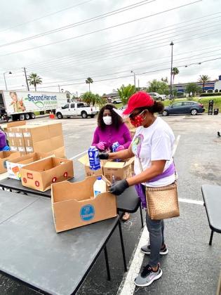 Clarita's House Outreach Ministry Founder and Executive Director Doreen Barker puts milk on one of the tables. NEWS-GAZETTE PHOTO/BRIAN MCBRIDE