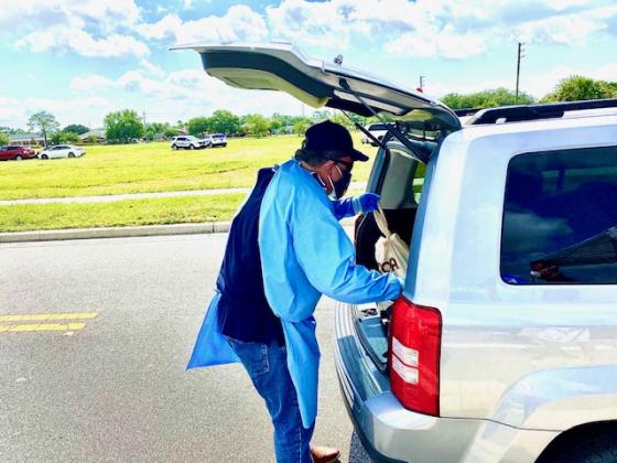 Kissimmee Mayor Jose Alvarez places food in the back of a vehicle. NEWS-GAZETTE PHOTO/BRIAN MCBRIDE