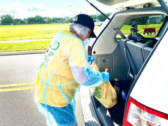 Kissimmee City Commissioner Olga Gonzalez helps out. NEWS-GAZETTE PHOTO/BRIAN MCBRIDE