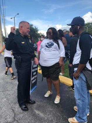 Kissimmee Police Chief Jeff O’Dell speaks with Kay Odem, who helped organize the protest. NEWS-GAZETTE PHOTO/CHARLIE REED