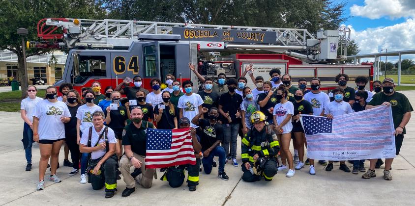 Following Liberty High School Patriot Day stair climb event, the crew from Osceola Fire Rescue & EMS Ladder 64 posed for a photo with students and faculty of the school, and also allowed them to inspect their vehicle and firefighting equipment.