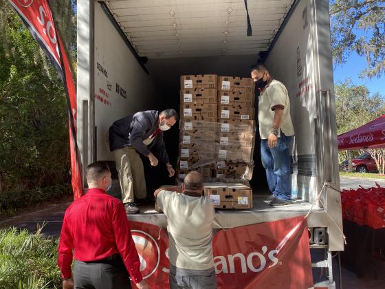 Sedano's staff members unload a pallet of food from a truck. NEWS-GAZETTE PHOTO/BRIAN MCBRIDE