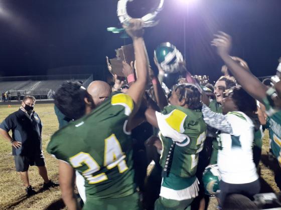 Liberty football players celebrate by mobbing head coach Brandon Pennington and the Battle of the Boulevards trophy following their 22-7 win over Poinciana.  It was the Chargers 14th consecutive win in the series in as many tries.  News-Gazette Photo/ J. Daniel Pearson