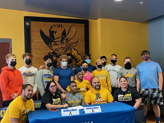 Surrounded by his parents, family and teammates, Jaekus Hines signs his letter-of-intent to wrestle for Appalachian State University. Photo courtesy of Osceola High School.