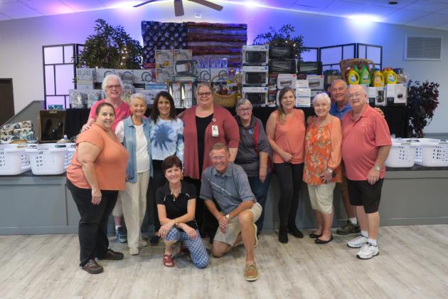 Kissimmee Elks Lodge members stand in front of household items collected for veterans.