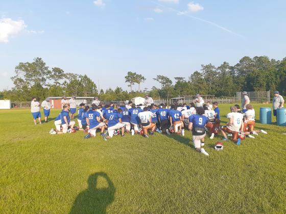 Head Coach Don Simon (center) talks to his team after a spring practice. News-Gazette Photo/J Daniel Pearson