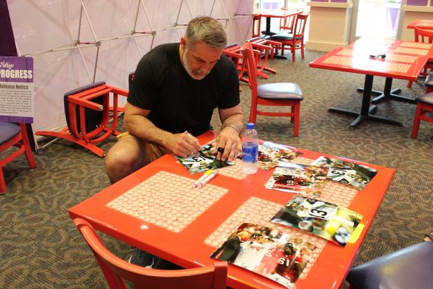 Kurt Warner signs memorabilia at Give Kids the World Village on July 14. PHOTO/KEN JACKSON