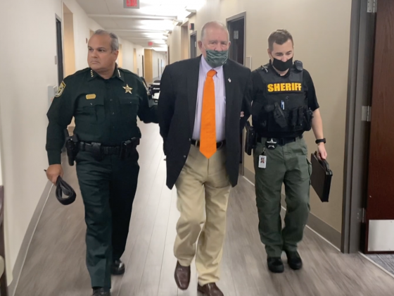 Attorney Hal Uhrig is taken into custody Monday by the Osceola County Sheriff's Office and Sheriff Marcos Lopez (left). PHOTO/OSCEOLA COUNTY SHERIFF'S OFFICE