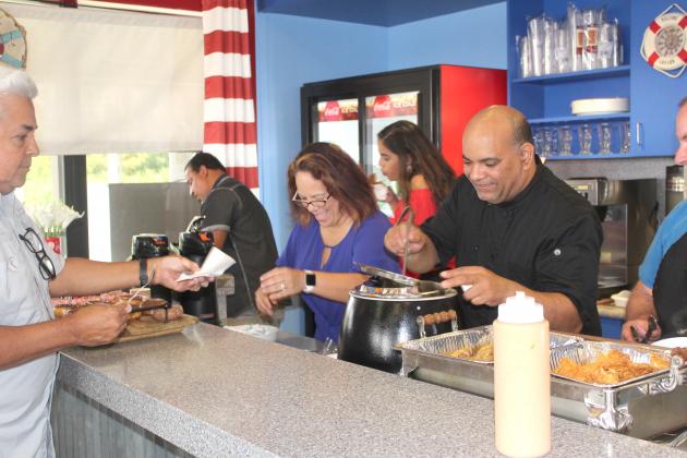 Jackie and Jorge Espinosa serve up samples of their new menu items at Big Toho Marina Thursday. They expect to open this weekend. PHOTO/KEN JACKSON