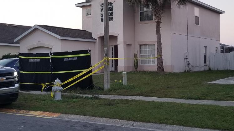 A pair of evidence markers were in the yard at 109 Windy Dune Court, and a black curtain was up to try to block the view from nearby neighbors and onlookers.
