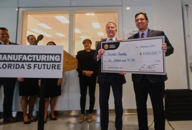 Osceola County Manager Don Fisher accepted a $6 mllion "check" from Gov. Ron DeSantis to help fund Neovation Way, a NeoCity connector road to Neptune Road. PHOTO/OSCEOLA COUNTY
