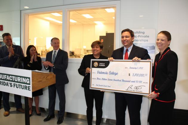 Valencia College President Kathleen Plinske accepted a $3.7 million "check" from Gov. Ron DeSantis to fund new programs that focus technology workforce training for semiconductor industries. PHOTO/KEN JACKSON