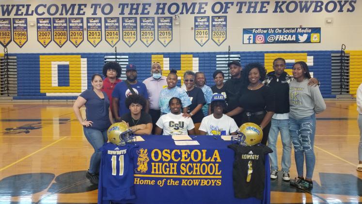Seated from left, Elijah Peters (Webber), Kaylon Walters (Charleston Southern) and Christian Combs (Allen U.) locked in their college football choices Wednesday. PHOTO/KEN JACKSON