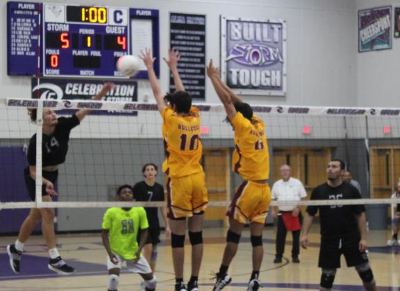 Celebration's Lucas Nieves (14) hits as St. Cloud's Angelo Gutierrez (6) and William Sutphen (10) attempt to block in Tuesday's regional boys volleyball playoff game. PHOTO/KEN JACKSON