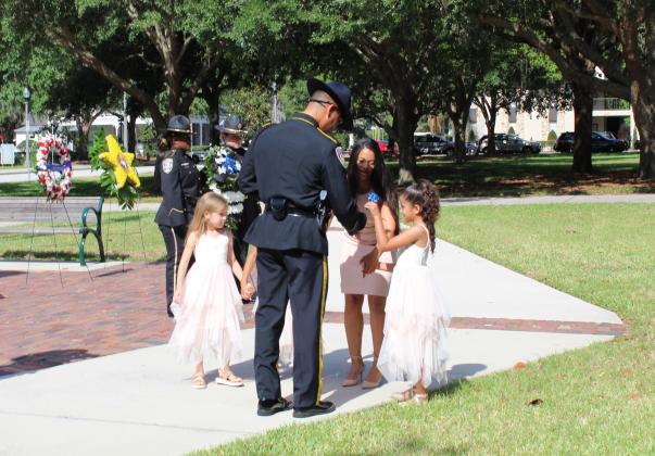 The children of fallen Kissimmee Police Officer Matthew Baxter receive flowers to place on a wreath at Wednesday's Law Enforcement Memorial. PHOTO/KEN JACKSON