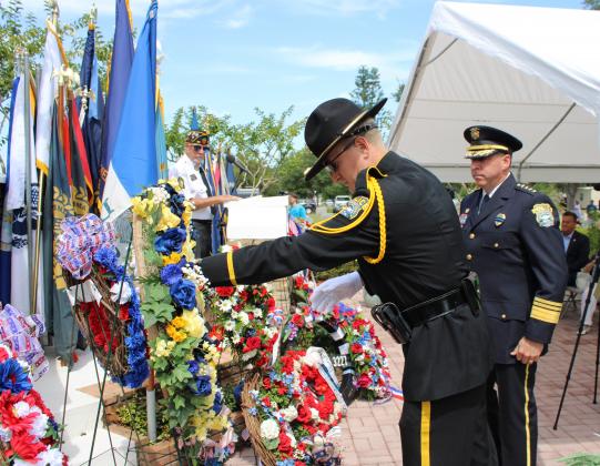 Members of the St. Cloud Police Department present flowers during Monday's Mount Peace Memorial Day service.