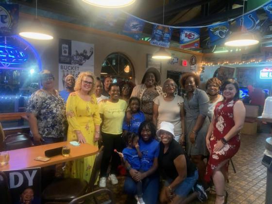 Angela Eady (back row in hat) celebrates her election win and return to Kissimmee City Hall with family and friends at PG's Wings Tuesday night. PHOTO/NATALIE FEDOR