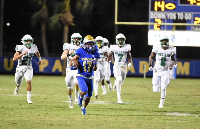 Kowboys return specialist Elijah Jenkins outruns a host of Deland defenders on his way to a 99-yard kickoff return for a touchdown in the second quarter of the Bulldogs playoff game with Osceola. PHOTO/JANA STULTZ