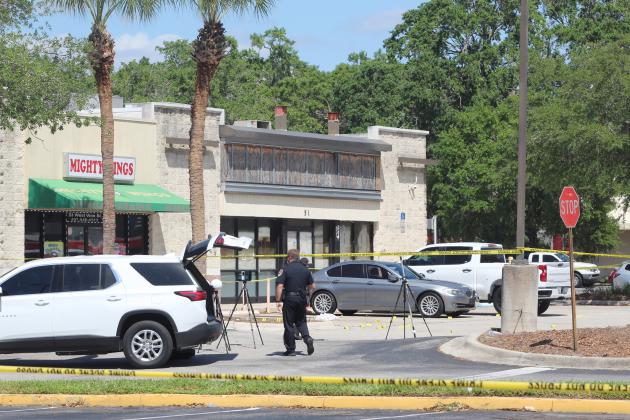 Numerous evidence markers note where Kissimmee Police investigators found shell casings after a shooting last Thursday in a restaurant parking lot at Vine Street and Orange Blossom Trail. One person was left dead, and KPD has not made a formal arrest while possibly having a suspect(s) who haven't made a statement yet. PHOTO/KEN JACKSON.