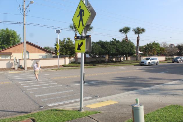 A resident uses a signaled crosswalk that slows traffic on Polynesian Isle Boulevard. PHOTO/KEN JACKSON